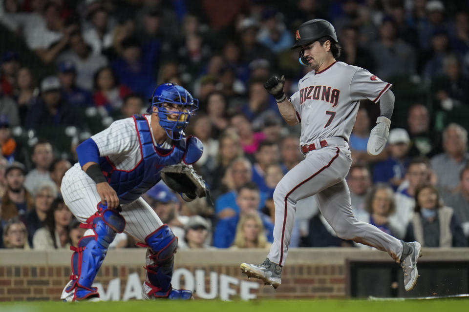 Arizona Diamondbacks' Corbin Carroll, right, runs past Chicago Cubs catcher Yan Gomes to score on a single by Ketel Marte during the ninth inning of a baseball game Thursday, Sept. 7, 2023, in Chicago. (AP Photo/Erin Hooley)