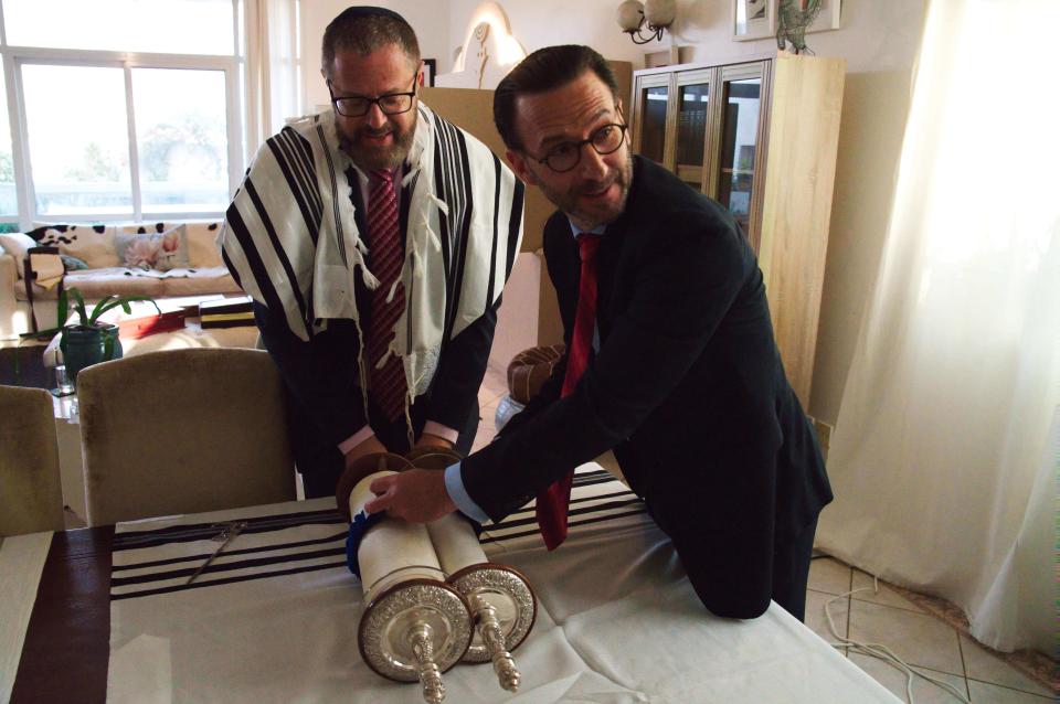 Alex Peterfreund, a co-founder of Dubai's Jewish community and its cantor, left, and Ross Kriel, the president of the Jewish Council of the Emirates, right, prepare to put away a Torah in Dubai, United Arab Emirates, Sunday, Aug. 16, 2020. Telephone service between the United Arab Emirates and Israel began working Sunday as the two countries opened diplomatic ties, part of a deal brokered by the U.S. that required Israel to halt its contentious plan to annex West Bank land sought by the Palestinians for a future state. (AP Photo/Jon Gambrell)