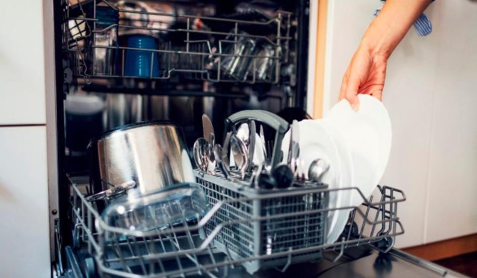 hand taking a clean plate out of the dishwasher