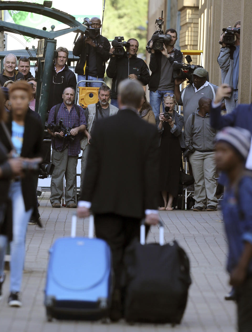 Journalists wait for the arrival of Oscar Pistorius at the high court in Pretoria, South Africa, Tuesday, April 8, 2014. Pistorius, who is charged with murder for the shooting death of his girlfriend, Reeva Steenkamp, on Valentines Day in 2013, was testifying for a second day at his murder trial Tuesday, answering questions from his defense lawyer. (AP Photo/Themba Hadebe)