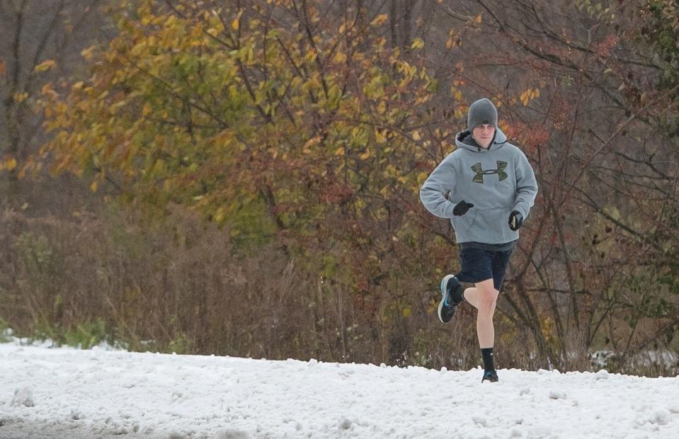 A runner jogs in shorts along Valley Road in Hockessin as snow rolls into Delaware and the surrounding area in 2018.