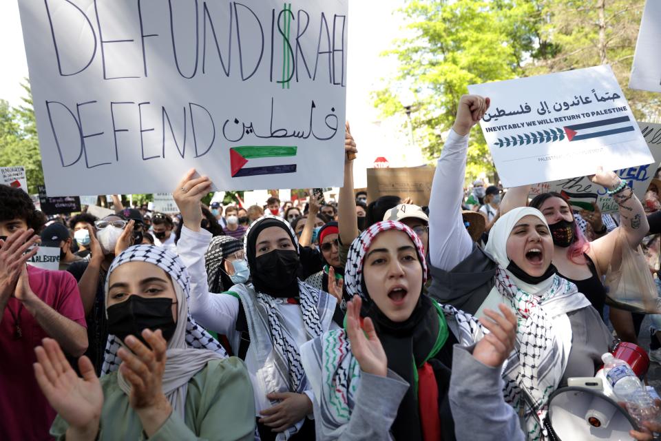 A woman holds a sign reading "Defund I$rael, Defend Palestine" at a protest outside the Israeli Embassy in Washington, D.C., May 18, 2021.