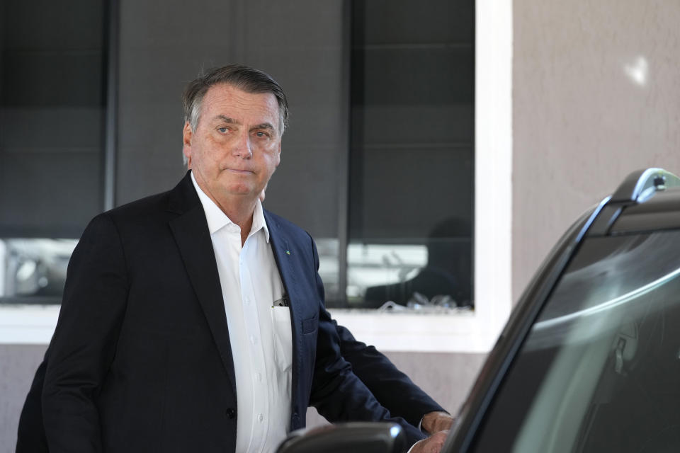 Former Brazilian President Jair Bolsonaro enters a car after speaking to the press outside his home after Federal Police agents carried out a search and seizure warrant in Brasilia, Brazil, Wednesday, May 3, 2023. When asked about the search of Bolsonaro’s home in Brasilia, the Federal Police press office gave a statement saying officers were carrying out searches and arrests related to the introduction of fraudulent data related to the COVID-19 vaccine into the nation’s health system. (AP Photo/Eraldo Peres)