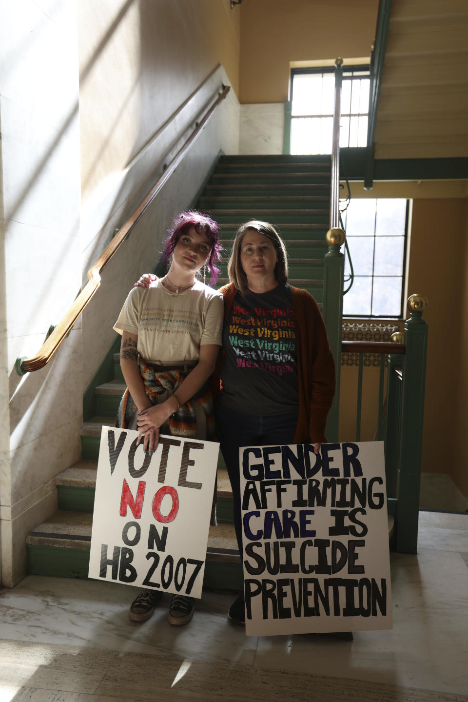 Cecilia Moran, 18, from Fairmont, and her mother, Rebecca Moran, hold signs protesting HB 2007, which would ban health care for trans children, at the state capitol in Charleston, W.Va., on March 9, 2023. (AP Photo/Chris Jackson)