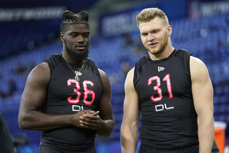 Michigan defensive lineman David Ojabo talks with Michigan defensive lineman Aidan Hutchinson, right, at the NFL football scouting combine, Saturday, March 5, 2022, in Indianapolis. (AP Photo/Charlie Neibergall)