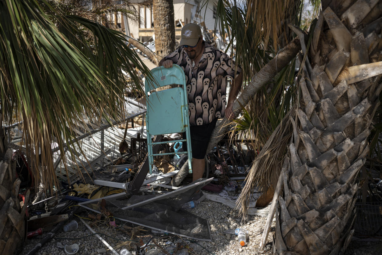 Michael Yost finds a chair at the destroyed home of his friend Mitch Pacyna. (Thomas Simonetti for NBC News)