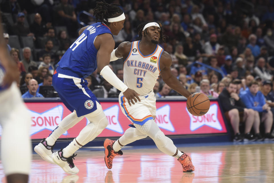 Oklahoma City Thunder forward Luguentz Dort (5) pushes past Los Angeles Clippers forward Terance Mann (14) in the first half of an NBA basketball game, Thursday, Oct. 27, 2022, in Oklahoma City. (AP Photo/Kyle Phillips)