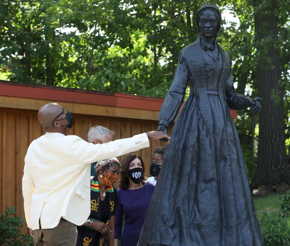 Cory Mcliechey, a fifth-generation descendent of Sojourner Truth, grasps the hand of the monument unveiled in her honor upon its dedication Aug. 26, 2020.