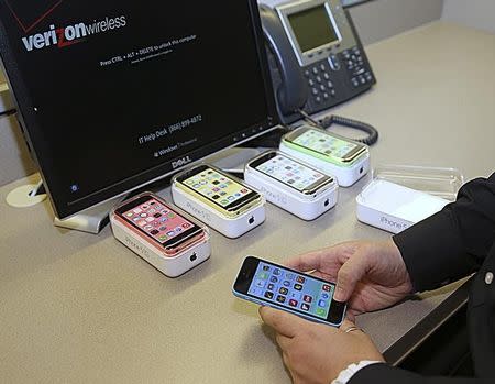 An employee prepares an Apple iPhone 5C for display at a Verizon store in Orem, Utah September 19, 2013. REUTERS/George Frey