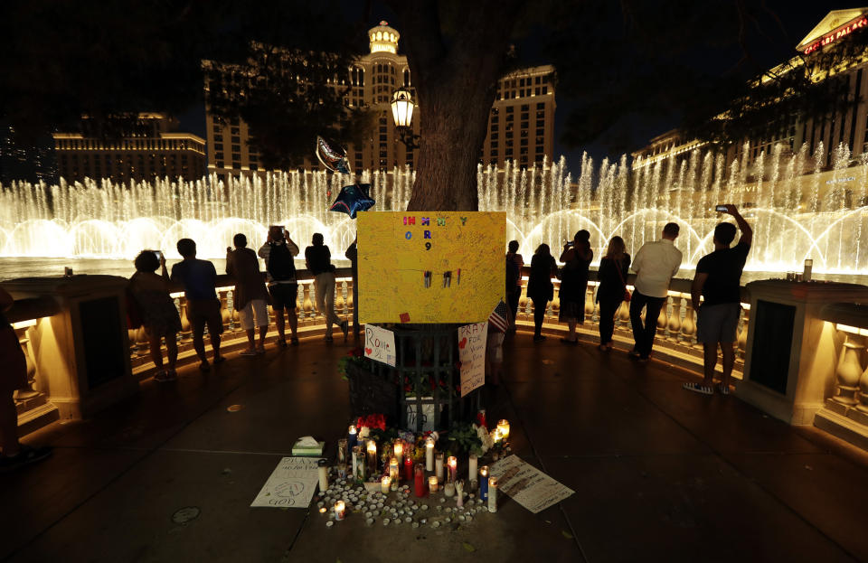 <p>People take photos of the fountain at the Bellagio hotel in front of a memorial for victims of the mass shooting in Las Vegas, Tuesday, Oct. 3, 2017. (Photo: Gregory Bull/AP) </p>