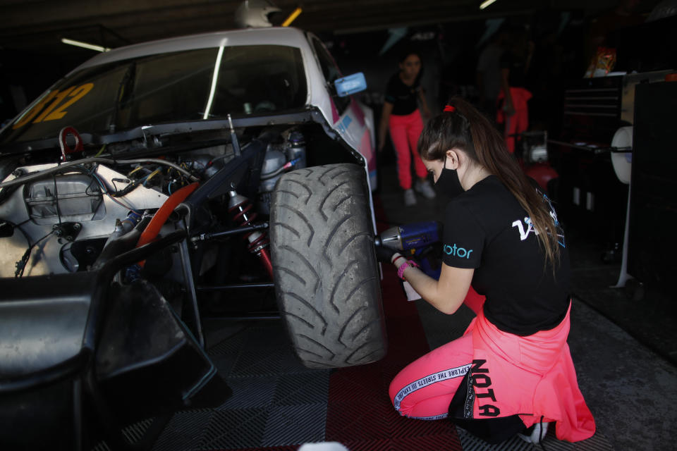 Vitarti Girl’s Team mechanic Paula Salazar works on driver Karina Dobal's car at pits at the Oscar y Juan Galvez track in Buenos Aires, Argentina, Friday, April 2, 2021. While many auto racing competitions are open to both male and female drivers, it's rare to see women making up the entire crew checking engines, putting on tires and analyzing race times, like the all-female Vitarti Girl’s Team. (AP Photo/Natacha Pisarenko)