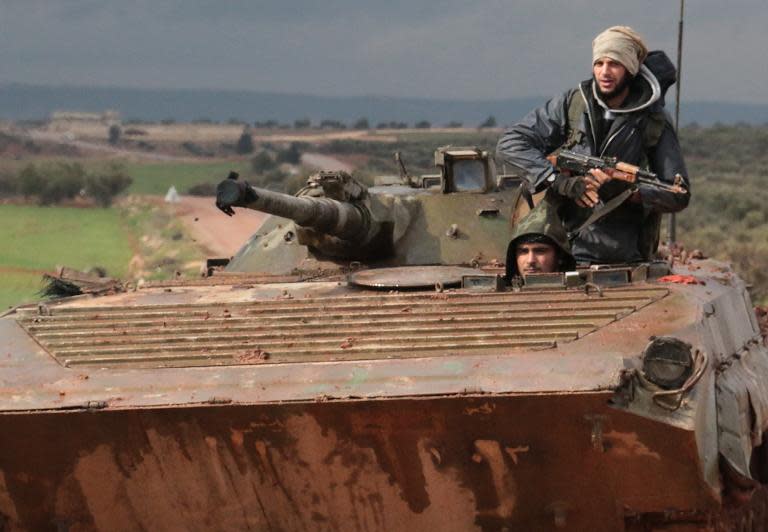 Rebel fighters drive a tank near the frontline in the village of Ratyan in the countryside north of the Syrian city of Aleppo on February 19, 2015