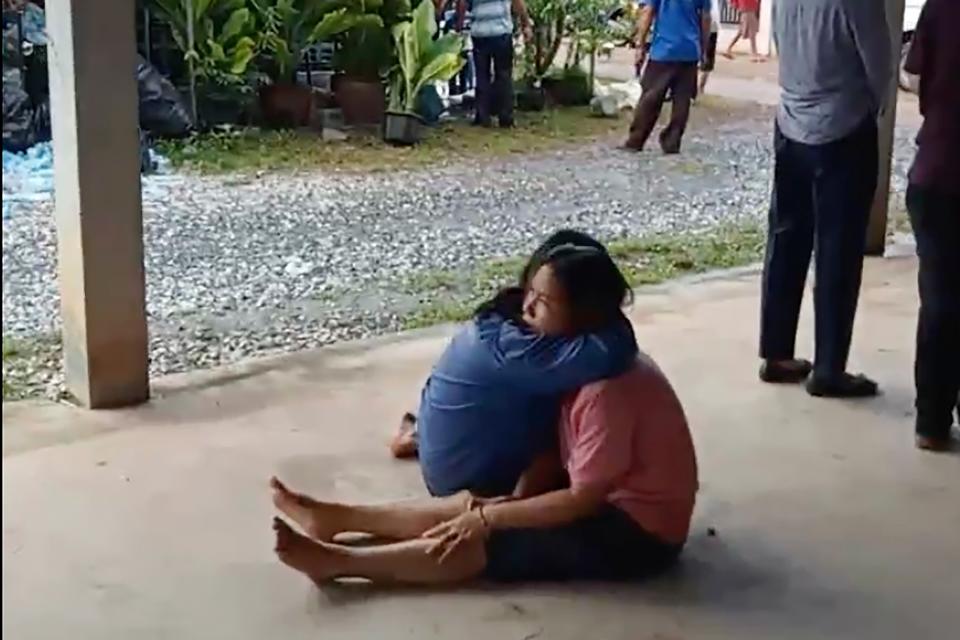 In this image taken from video, a distraught woman is comforted outside the site of an attack at a daycare center (AP)