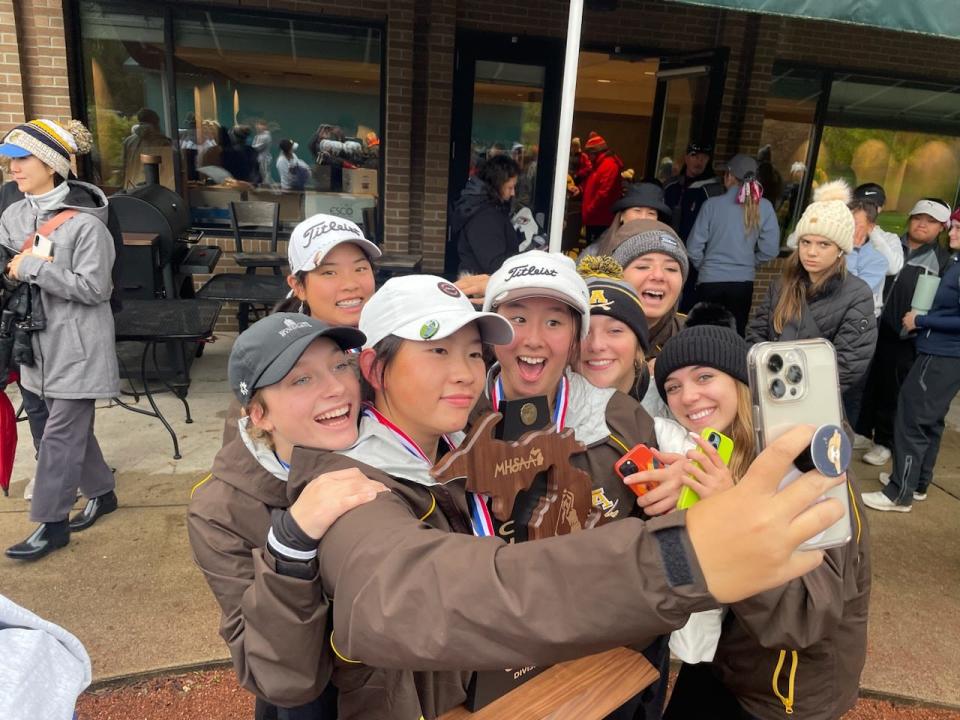 The Rochester Adams girls golf team celebrates its Division 1 state championship on Saturday at Michigan State.