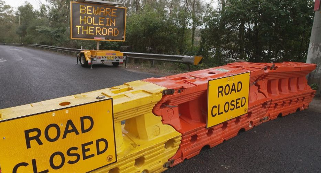 Bollards and road closure signs at River Road in Wisemans Ferry. 