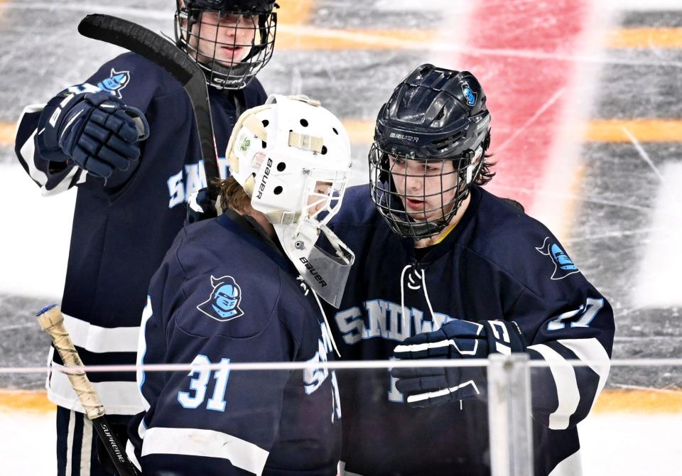 Sandwich players Devan Mahoney (right) and Logan Munk console their goalie Mitchell Norkevicius after losing to Norwell 4-3 in overtime in the MIAA Division 4 final hockey match at TD Garden in Boston March 19.