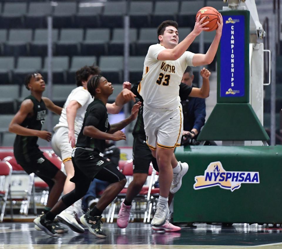 Victor's Nick Leonard (33) grabs a rebound in front of Brentwood's Jerimiah Webb during a NYSPHSAA Class AA Boys Basketball Championship semifinal in Glens Falls, N.Y., Friday, March 17, 2023. Victor advanced to the Class AA title game with a 56-41 win over Brentwood-XI.