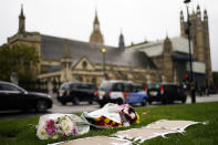 Flowers are placed as a tribute in Parliament Square following Friday's death of member of Parliament David Amess in Leigh-on-Sea, Essex, in London, Saturday, Oct. 16, 2021. Leaders from across the political spectrum came together Saturday to pay tribute to a long-serving British lawmaker who was stabbed to death in what police have described as a terrorist incident. (Aaron Chown/PA via AP)