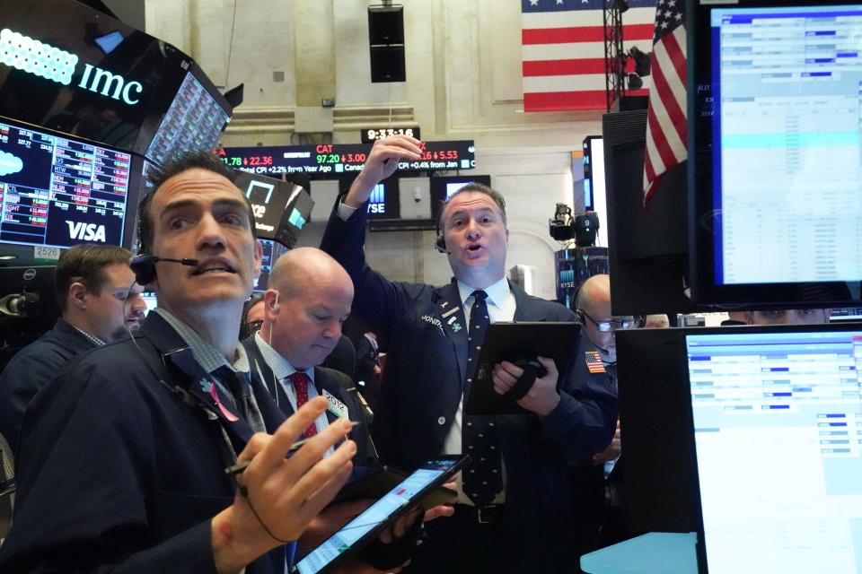 Traders work on the floor at the opening bell of the Dow Industrial Average at the New York Stock Exchange on March 18, 2020 in New York. - Wall Street stocks resumed their downward slide early Wednesday as the economic toll mounts from the rapid near-shutdown of key industrial and services sectors.About 15 minutes into trading, the Dow Jones Industrial Average stood at 20,040.66, down around 1,200 points or 5.6 percent. (Photo by Bryan R. Smith / AFP) (Photo by BRYAN R. SMITH/AFP via Getty Images)