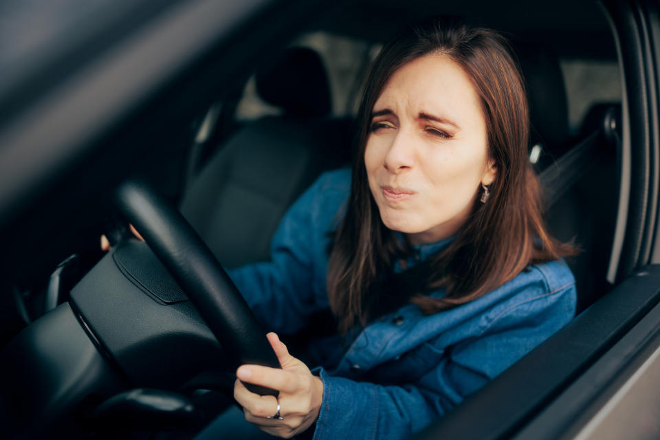 A woman driving and trying to see