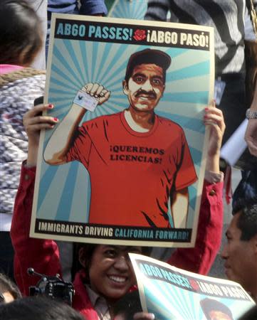 A guest holds a poster celebrating the signing of AB60 into law after bill-signing ceremonies by California Governor Jerry Brown (unseen) in Los Angeles October 3, 2013. REUTERS/Fred Prouser