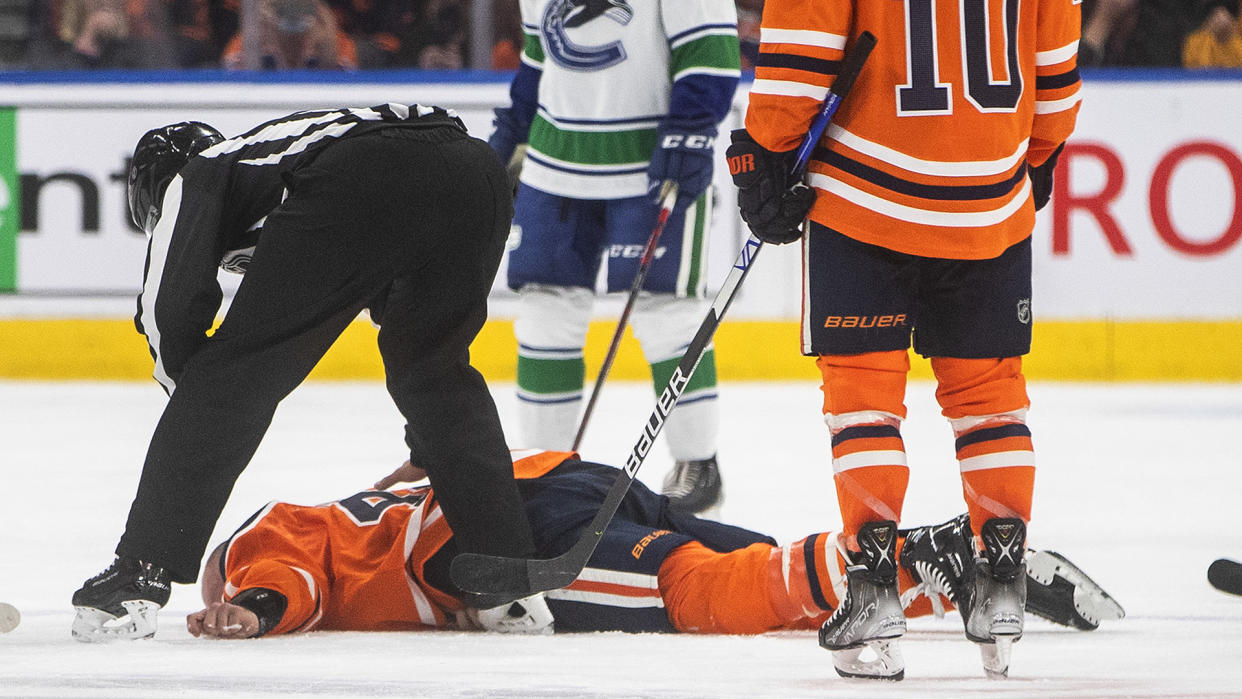 Edmonton Oilers' Zack Kassian (44) lies on the ice after a fight with Vancouver Canucks' Zack MacEwen (71). (THE CANADIAN PRESS/Jason Franson)