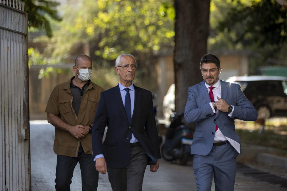 Members of Carlos Ghosn's defense team, lawyer Jean Yves Le Borgne, center, and Jean Tamalet, right, leave the Justice Palace in Beirut, Lebanon, Monday, May 31, 2021. A team of French investigators began questioning ex-Nissan boss Carlos Ghosn in Beirut on Monday over suspicions of financial misconduct, Lebanese judicial officials said. (AP Photo/Hassan Ammar)