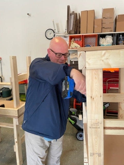 Temple Israel Rabbi David Komerofsky assembles a homework desk, one of 130 built and donated to local schools and charities by the Temple Israel Brotherhood. Ten desks are being donated the the US Together refugee resettlement program.