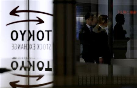 Visitors walk near logos of the Tokyo Stock Exchange (TSE) at the TSE in Tokyo January 30, 2014. REUTERS/Toru Hanai