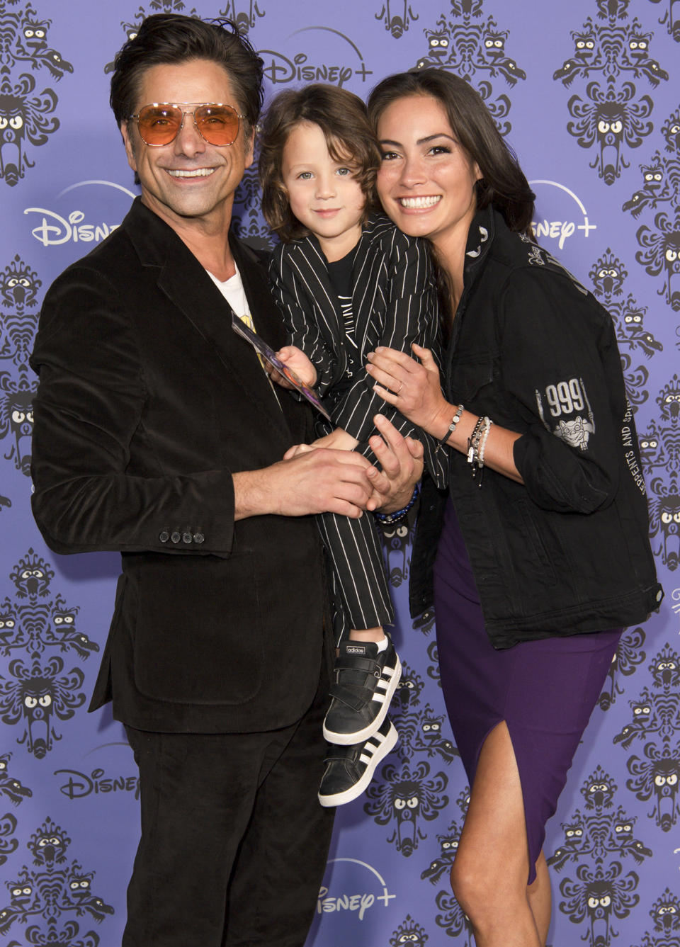 <p>John Stamos, wife Caitlin and their son Billy stick together on Oct. 7 at the Los Angeles premiere of <em>Muppets Haunted Mansion. </em></p>