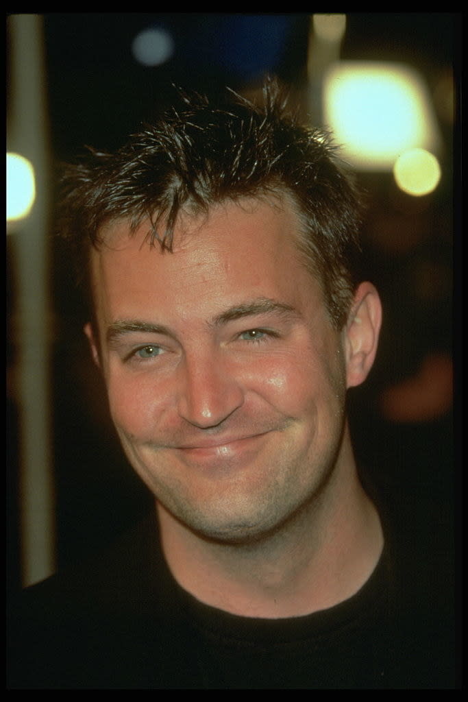 Smiling at a movie premiere, with gelled hair