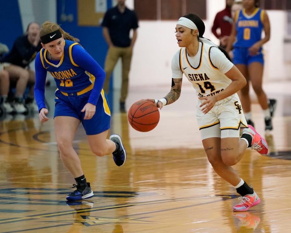 Sha’Kyla Parker of Siena Heights advances the ball downcourt against Madonna’s Sarah Tanderys during a 79-27 Siena Heights win Wednesday night.