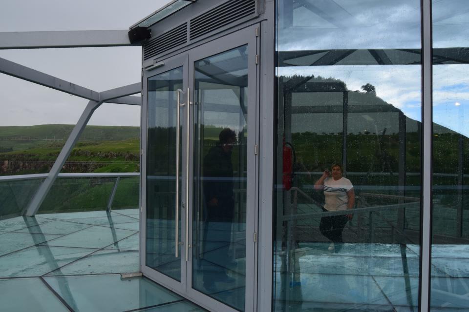 a glass bridge and diamond-shaped bar in the middle, suspended over the Dashbashi Canyon in Georgia