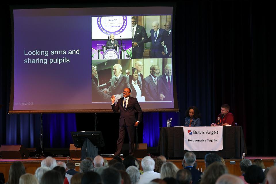 Elder Ahmad S. Corbitt, General Authority Seventy of The Church of Jesus Christ of Latter-day Saints, points to a photo of church President Russell M. Nelson as Elder Corbitt speaks at the Braver Angels National Convention at Gettysburg College in Gettysburg, Pa., on Thursday, July 6, 2023. | Kristin Murphy, Deseret News