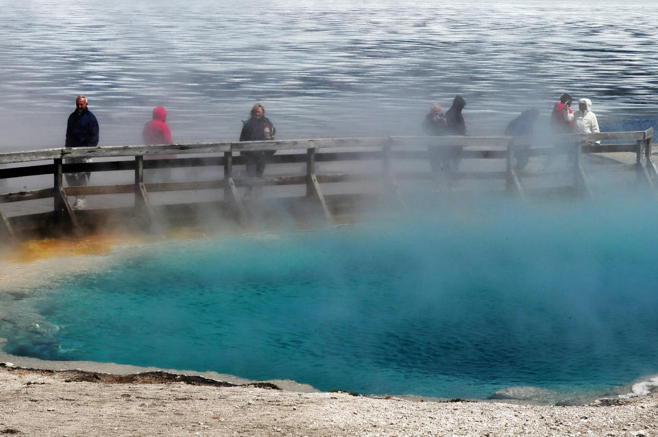 Tourists walk beside a hot spring at the West Thumb Geyser Basin in the Yellowstone National Park. Park officials said a man fell into a thermal hot spring and suffered severe burns on Sunday. (Photo: MARK RALSTON via Getty Images)