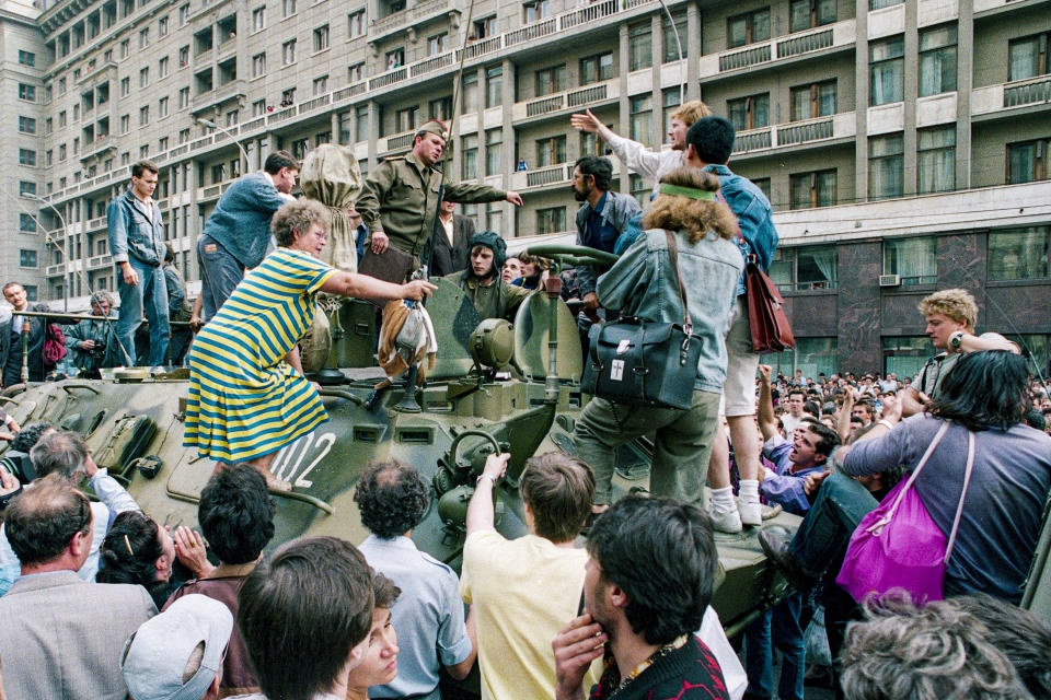 FILE - In this Monday, Aug. 19, 1991 file photo, a crowd gathers around a personnel carrier as some people climb aboard the vehicle and try to block its advance near Red Square in downtown Moscow, Russia. When a group of top Communist officials ousted Soviet leader Mikhail Gorbachev 30 years ago and flooded Moscow with tanks, the world held its breath, fearing a rollback on liberal reforms and a return to the Cold War confrontation. But the August 1991 coup collapsed in just three days, precipitating the breakup of the Soviet Union that plotters said they were trying to prevent. (AP Photo/Boris Yurchenko, File)