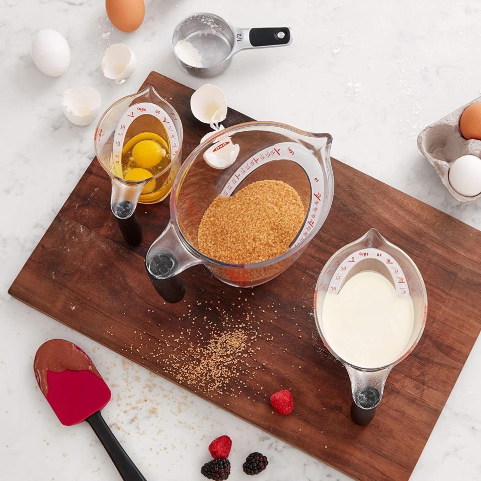 three angled measuring cups shot from above that show eggs, sugar, and milk in them