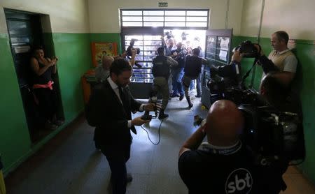 Police officers attempt to hold back journalists before Brazil's former President Dilma Rousseff (not pictured) votes during municipal elections in Porto Alegre, Brazil, October 2, 2016. REUTERS/Diego Vara