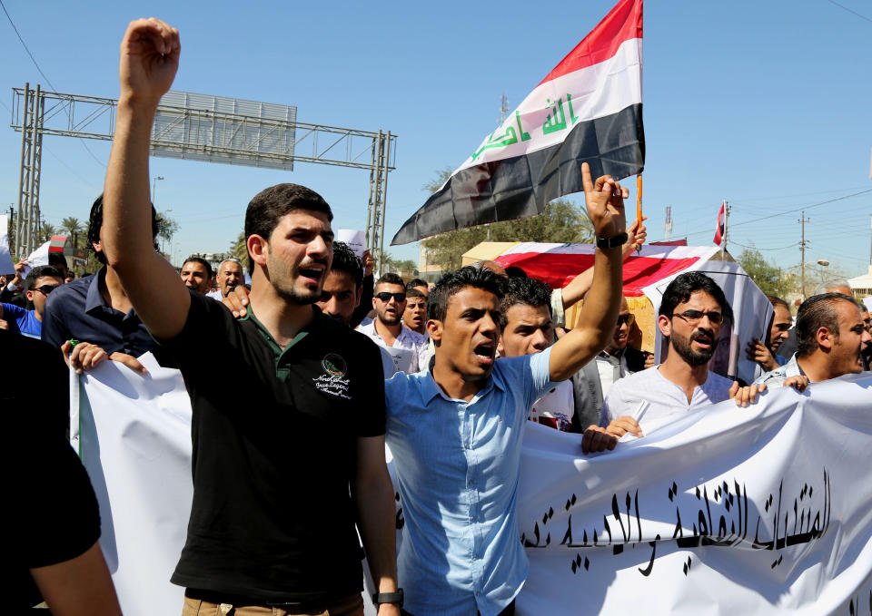 Mourners chant slogans during a symbolic funeral for the bureau chief of a local radio station in Baghdad, Iraq, Sunday, March 23, 2014. A junior officer working for Iraqi President Jalal Talabani, also an ethnic Kurd, shot dead Mohammed Bdaiwi, a well-known radio journalist during a quarrel Saturday near the leader's east Baghdad residence, police said. (AP Photo/Karim Kadim)