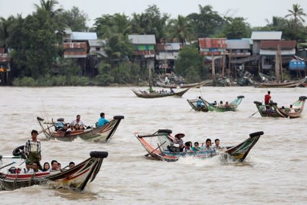 People living on the other side of the river, the site of the proposed New Yangon City project site, arrives for school and work by boat in the early morning in Yangon