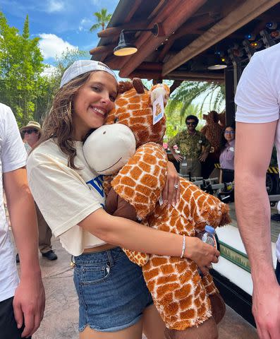 <p>Millie Bobby Brown/Instagram</p> Millie Bobby Brown holds a plush giraffe at Universal Studios in Orlando, Florida