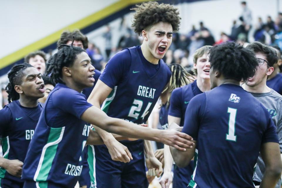 Great Crossing's Malachi Moreno (24) and teammates mob Vince Dawson (1) in jubilation after Dawson's last second shot lifted the Warhawks 48-46 over Newport at Thursday's 2023 Chad Gardner Law King of the Bluegrass holiday basketball tournament at Fairdale High School. Dec. 21, 2023