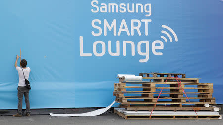 A man works on the Samsung booth before the IFA consumer electronics fair in Berlin, August 28, 2012. REUTERS/Tobias Schwarz/File Photo