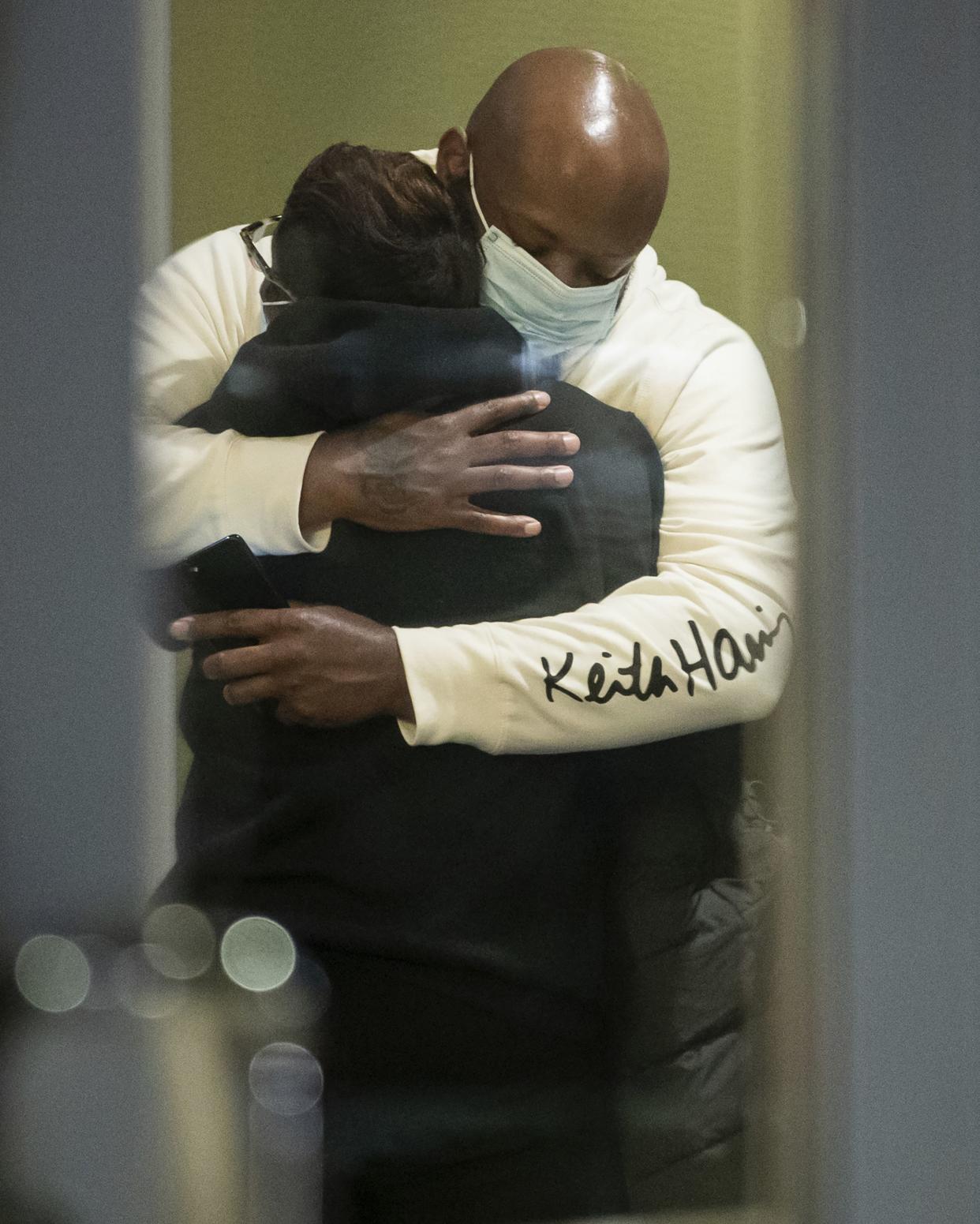 People hug after learning that their loved one is safe after a shooting inside a FedEx building Friday, April 16, 2021.