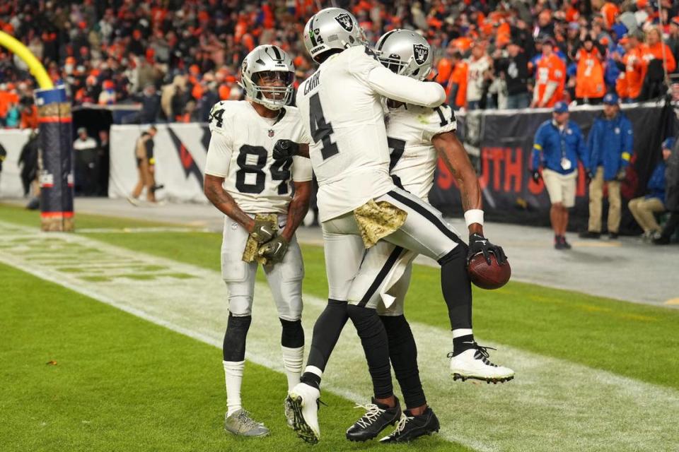 Las Vegas Raiders quarterback Derek Carr celebrates with wide receiver Davante Adams, right, and wide receiver Keelan Cole after Adams scored the winning touchdown during overtime of an NFL game against the Denver Broncos in Denver, Sunday, Nov. 20, 2022.