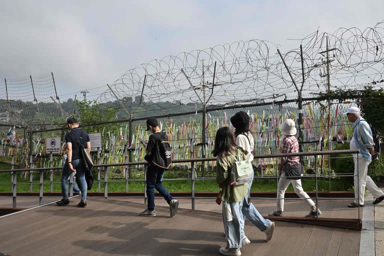 Visitantes caminan junto a una cerca militar en el parque de paz Imjingak en la ciudad fronteriza de Paju el 19 de julio de 2023.