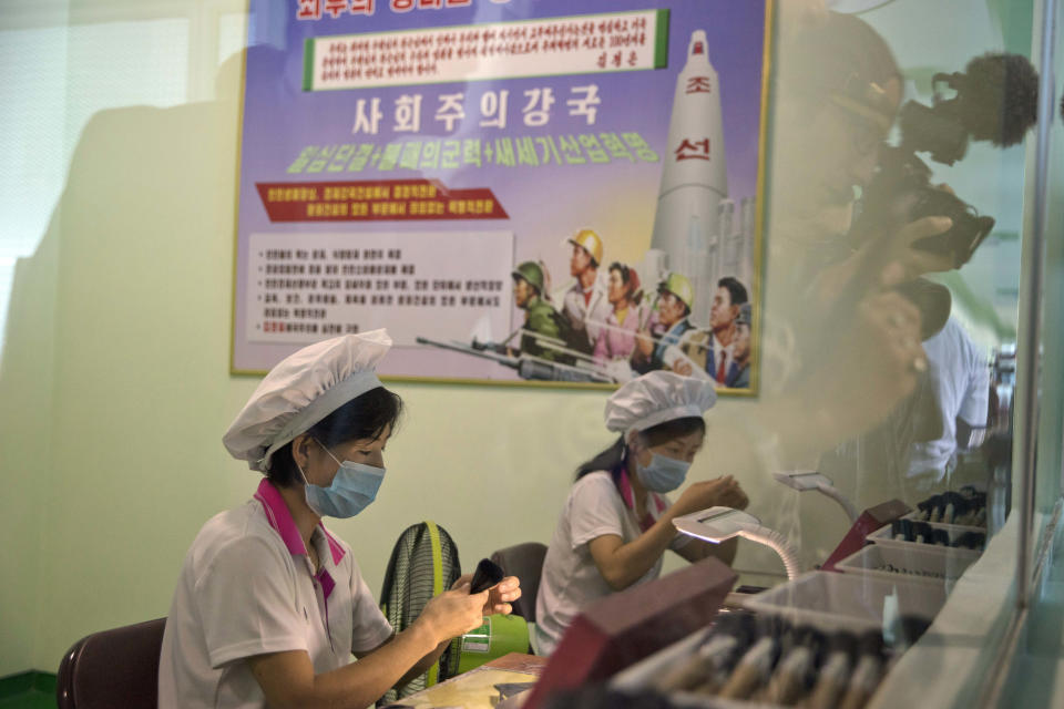 Workers produce cosmetic brushes at the Pyongyang Cosmetics Factory in Pyongyang, North Korea, Saturday, Sept. 8, 2018. The Pyongyang Cosmetics Factory, which was recently renovated, is one of the North’s main producers of cosmetic items. The poster reads "poweful socialisim." (AP Photo/Ng Han Guan)