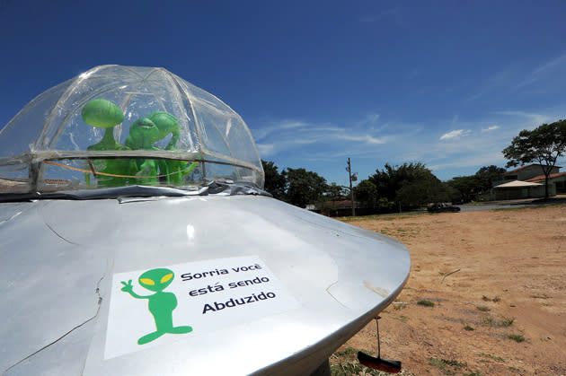 A mock UFO with alien dolls and reading "Smile, you are being abducted" is seen in Alto Paraiso town, Goias State, 230 kms north of Brasilia, on December 20, 2012. Situated over a huge quartz crystal plate, Alto Paraiso attracted many Brazilians and foreigners seeking refuge from the events expected by the Mayan prophecy that predicts the end of the world or the beginning of a new era. AFP PHOTO / Evaristo SA