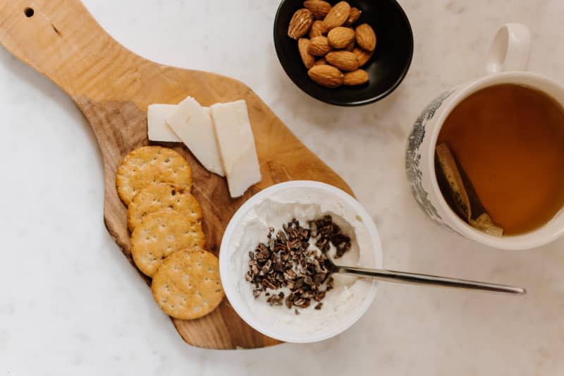 French lunch of yogurt, cheese, crackers and nuts.