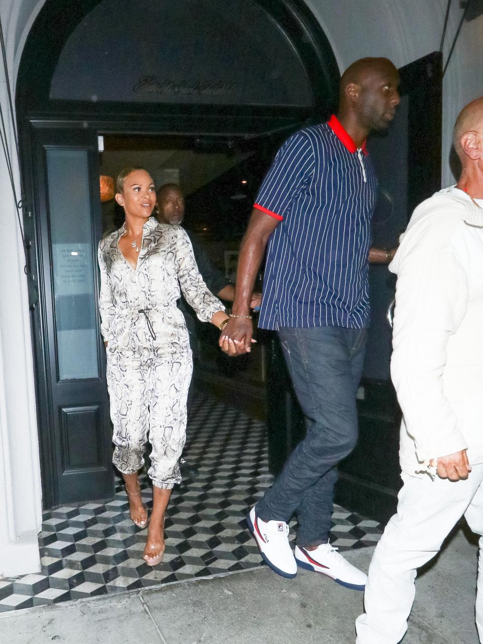 Lamar Odom and Sabrina Parr exit a venue